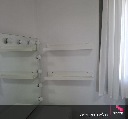 חדר עם מראה ומדפים על הקיר